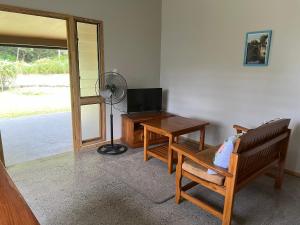 sala de estar con ventilador, mesa y sillas en Mareva Kore, en Avarua