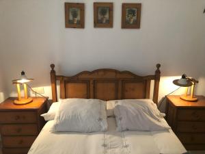 a bedroom with a bed with two lamps on night stands at Casa San Rafael, magnífico chalet con gran jardín in Navajas +33 photos
