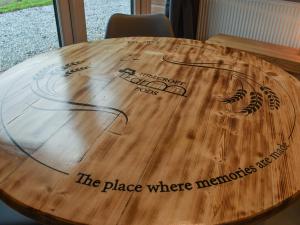 einen Holztisch mit einem Ort, an dem Erinnerungen warten in der Unterkunft Hayfield Haven-Uk40691 in Crowhurst