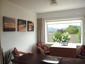 a living room with a window and a table and chairs at Peel Wyke in Keswick