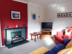a living room with a fireplace and a tv at Peel Wyke in Keswick