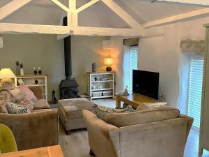 ein Wohnzimmer mit zwei Sofas und einem Kamin in der Unterkunft Lavender Barn in Newquay