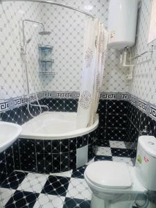 Un baño con bañera, inodoro y lavabo. en Hostel Marshal, en Termiz