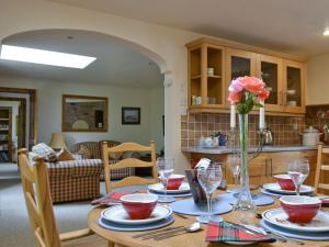 ein Esstisch mit einer Vase mit Blumen darauf in der Unterkunft Old Stones in Glendevon + 10 Fotos