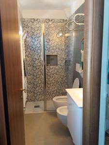 a bathroom with a shower with a toilet and sink at Madò Apartments Egnazia in Bari