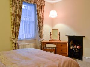 a bedroom with a bed and a fireplace and a mirror at Pear Tree Cottage in Bowness-on-Windermere
