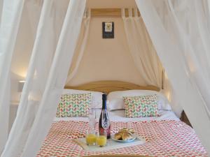 - un lit avec un plateau de nourriture et de boissons dans l'établissement The Cottage - Osd, à Penbryn 3 autres photos