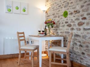 a table and chairs in a room with a stone wall at Old Orchard Barn - The Annexe in Buckland St Mary
