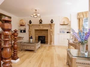 un salon avec une cheminée et une table dans l'établissement Copper Beech Cottage, à Henfynyw Upper