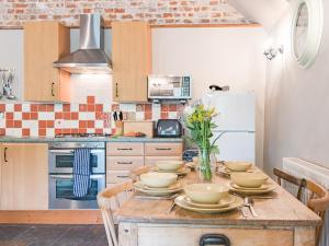 a kitchen with a wooden table with dishes on it at Kingfisher Oast in Hollingbourne