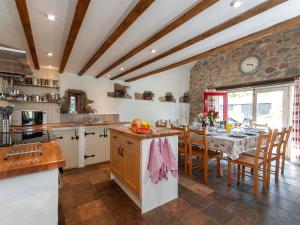 Una cocina y un comedor con mesa y sillas. en Ty Dewi - Qc1507, en Llanhowell