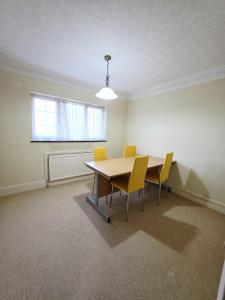 une pièce vide avec une table et des chaises jaunes dans l'établissement 3 Bedroom whole house with free car parking, à Leicester 10 autres photos