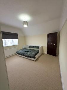 une chambre vide avec un lit et une fenêtre dans l'établissement 3 Bedroom whole house with free car parking, à Leicester