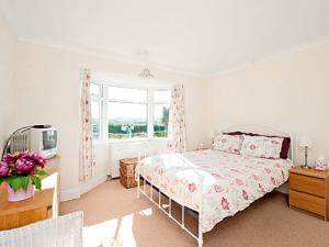 ランズウィックにあるSeacotのベッドと窓のある寝室