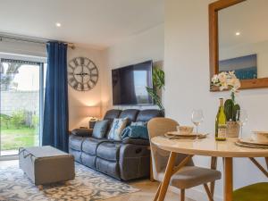 een woonkamer met een bank en een tafel bij Seascape in Sandown