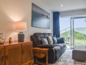 een woonkamer met een leren bank en een lamp bij Seascape in Sandown