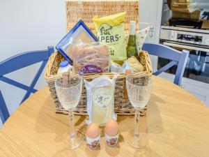 a basket with eggs and wine glasses on a table at Halton Lodge in Spilsby +16 photos