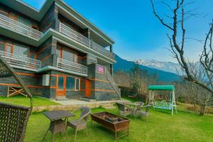 ein Haus mit einem Garten mit Stühlen und einer Feuerstelle in der Unterkunft Bentenwood Cottage - A Beautiful Boutique Cottage away from city hustle in Manali + 29 Fotos