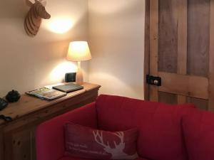 a living room with a red couch and a lamp at Overwater Lodge in Bassenthwaite Lake