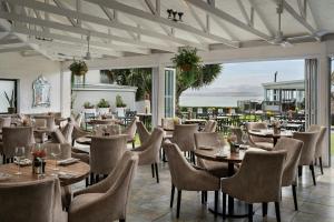 a restaurant with tables and chairs and a patio at Protea Hotel by Marriott Mossel Bay in Mossel Bay