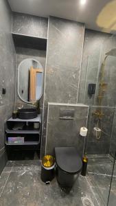 a bathroom with a black toilet and a mirror at Timeless luxury suites & SPA in Thessaloniki