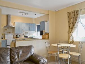 a kitchen with a couch and a table and chairs at Serendipity in Keswick