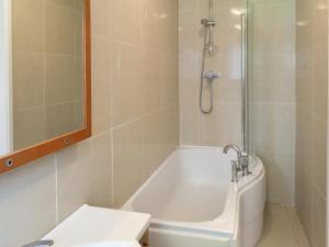 een badkamer met een bad, een wastafel en een douche bij Prudhoe Mews in Alnmouth +7 foto's