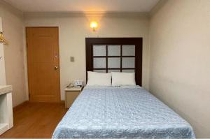a bedroom with a bed with a blue comforter at Washington Motel in Gangneung +9 photos