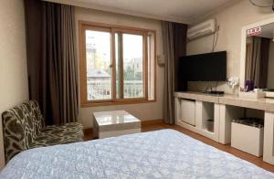 a hotel room with a bed and a window at Washington Motel in Gangneung