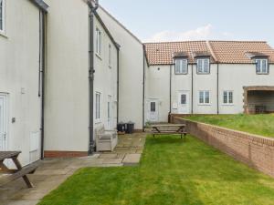 une rangée de bâtiments blancs avec une cour avec un banc dans l'établissement Meadow View, à Bridlington 7 autres photos