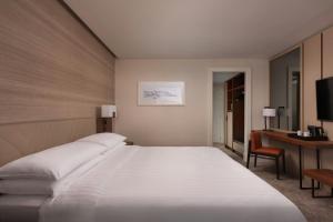 a bedroom with a large white bed and a desk at Lisbon Marriott Hotel in Lisbon