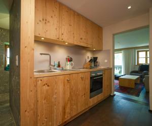 a kitchen with wooden cabinets and a sink at Alpine Chalet Apartment With Zugspitze Views in Grainau