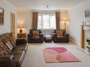 a living room with a couch and two chairs at Llwyn Ysgaw in Cemaes Bay