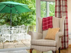 Blackberry Cottage في North Hill: كرسي مع وسادة وطاولة مع مظلة +7 صور