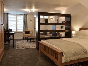 ein Schlafzimmer mit einem großen Bett und einem Schreibtisch in einem Zimmer in der Unterkunft Lower Sycamore Cottage in Ambleside