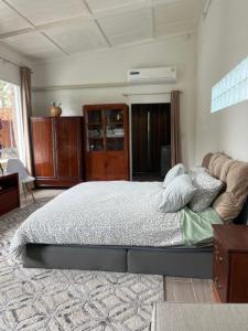 ein Schlafzimmer mit einem großen Bett und einer Kommode in der Unterkunft Phimai Pond House in Pi Mai