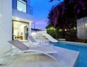 a group of white lounge chairs next to a swimming pool at ปาล์มสปริง by Nimo villa pattaya in Ban Nong Pru