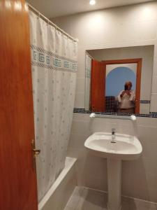 a bathroom with a sink and a person taking a picture in a mirror at TorrelagunaVera in Palomares