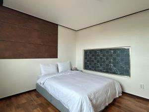 SongjŏngにあるGyeongpo Iris Stayのベッドルーム1室(壁にチョークボードのベッド1台付)