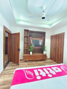 a living room with a television and a red blanket at Atiti Signature room 109 , zero mile in Patna