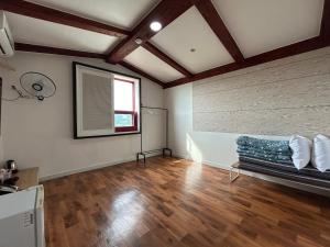 SongjŏngにあるGyeongpo Iris Stayの窓のある部屋にソファのある空き部屋