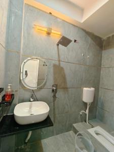 a bathroom with a sink and a mirror at Atiti Signature room 109 , zero mile in Patna