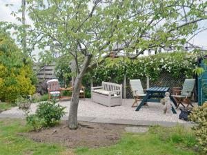 a patio with a table and chairs and a tree at Anchorage in Maidens