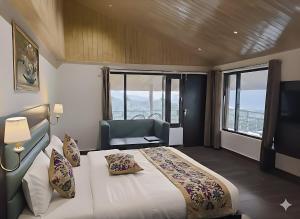 ein Schlafzimmer mit einem Bett und einem Stuhl und Fenstern in der Unterkunft Omavya Hotel Manali in Jagatsukh