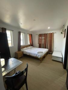 a bedroom with a bed and a table in it at Hao stay in Nadi