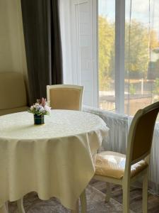 a white table with chairs and a vase of flowers on it at Hotel "CONTINENT" halal in Karagandy
