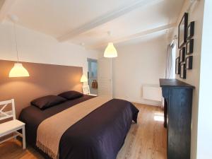 a bedroom with a large bed and two lights at Hyper centre, quartier du port in Audierne