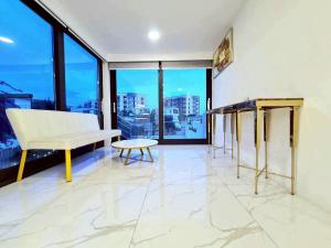 a living room with a white couch and a table at ปาล์มสปริง by Nimo villa pattaya in Ban Nong Pru