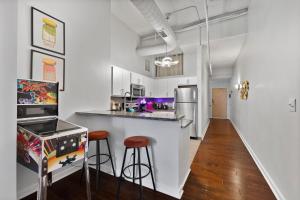 a kitchen with a counter and stools in a room at Downtown Indy 2BR - Stadium, Convention - Arcade Games - Skywalk in Indianapolis