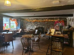 un restaurant avec des tables et des chaises et un mur de pierre dans l'établissement Coffee & Stays at Cartmel Square, à Cartmel 10 autres photos
